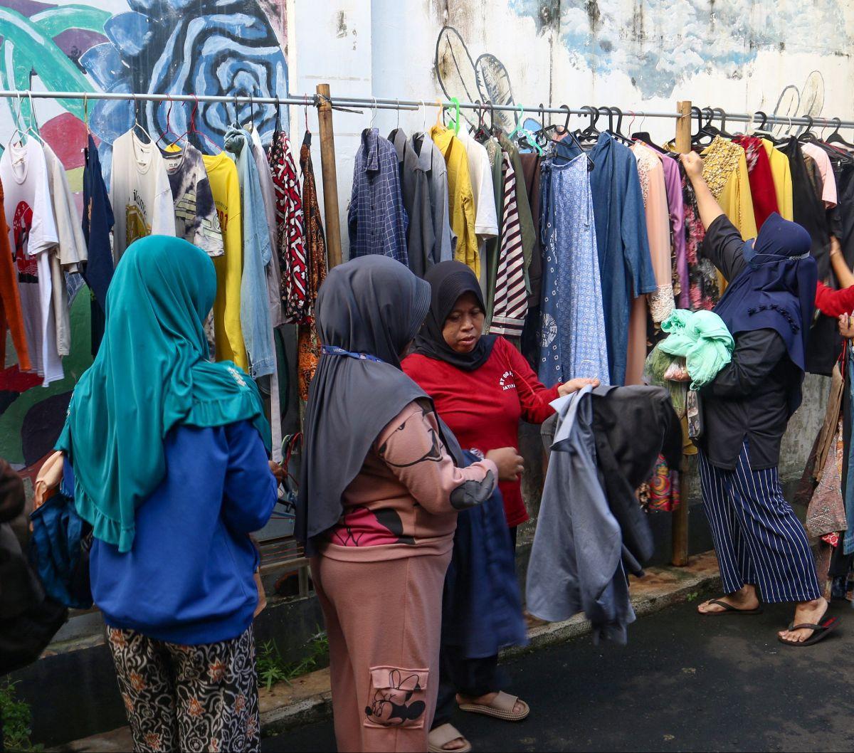Warga memilih pakaian saat bazar sayuran, bahan makanan dan bahu bekas layak pakai gratis di Jalan Jati Padang VI, Pasar Minggu, Jakarta, Jumat (29/3/2024). Ini menjadi tahun ke-7 bagi warga RT 002/004 Jati Padang dan para donatur menggelar bazar sayuran,