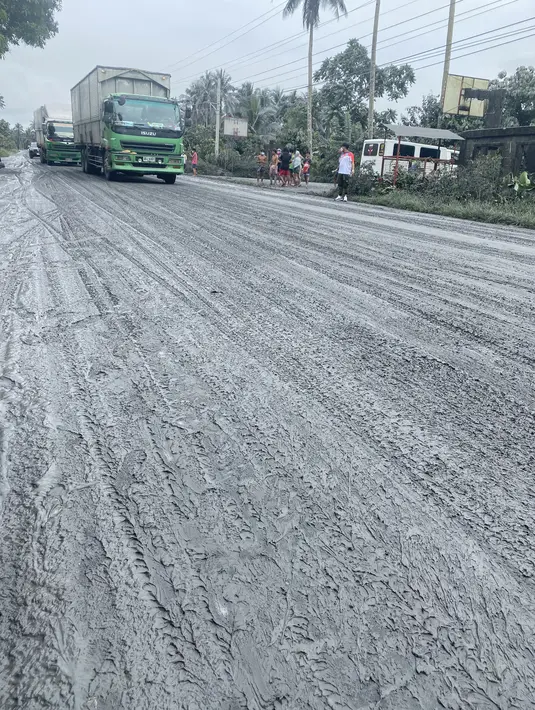 Foto selebaran pada 5 Juni 2022 menunjukkan kendaraan melaju di sepanjang jalan yang dipenuhi abu di kota Juban, provinsi Sorsogon, Filipina, setelah gunung berapi Bulusan meletus dan mengirimkan gumpalan abu ke daerah tersebut. Pihak berwenang menaikkan peringatan menjadi level satu pada sistem lima level yang menunjukkan "keresahan tingkat rendah". (Handout / Sorsogon Provincial Public Information Office / AFP)