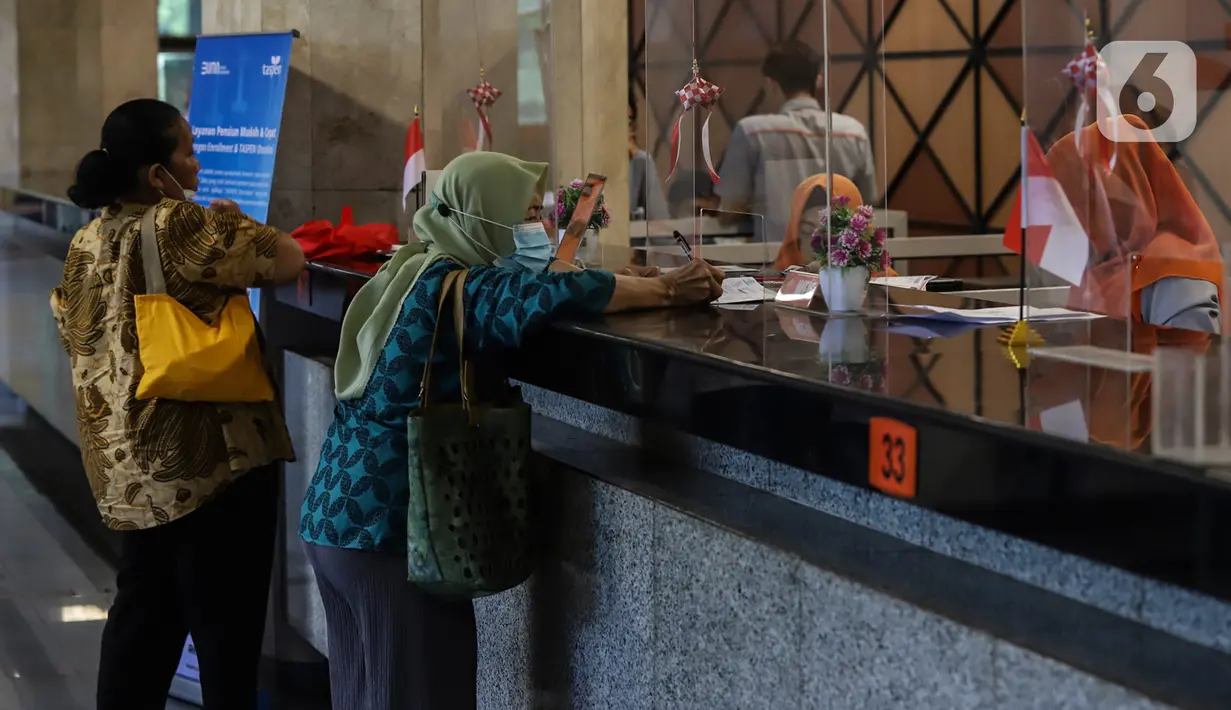 Petugas melayani sejumlah warga penerima bantuan langsung tunai (BLT) yang akan mencairkan uang sebesar Rp600 ribu yterkait kenaikan harga BBM di Kantor Pos Pasar Baru, Jakarta, Rabu (7/9/2022). BLT BBM 2022 diberikan kepada masyarakat yang terdaftar sebagai Keluarga Penerima Manfaat (KPM) dalam DTKS Kemensos. (Liputan6.com/Johan Tallo)