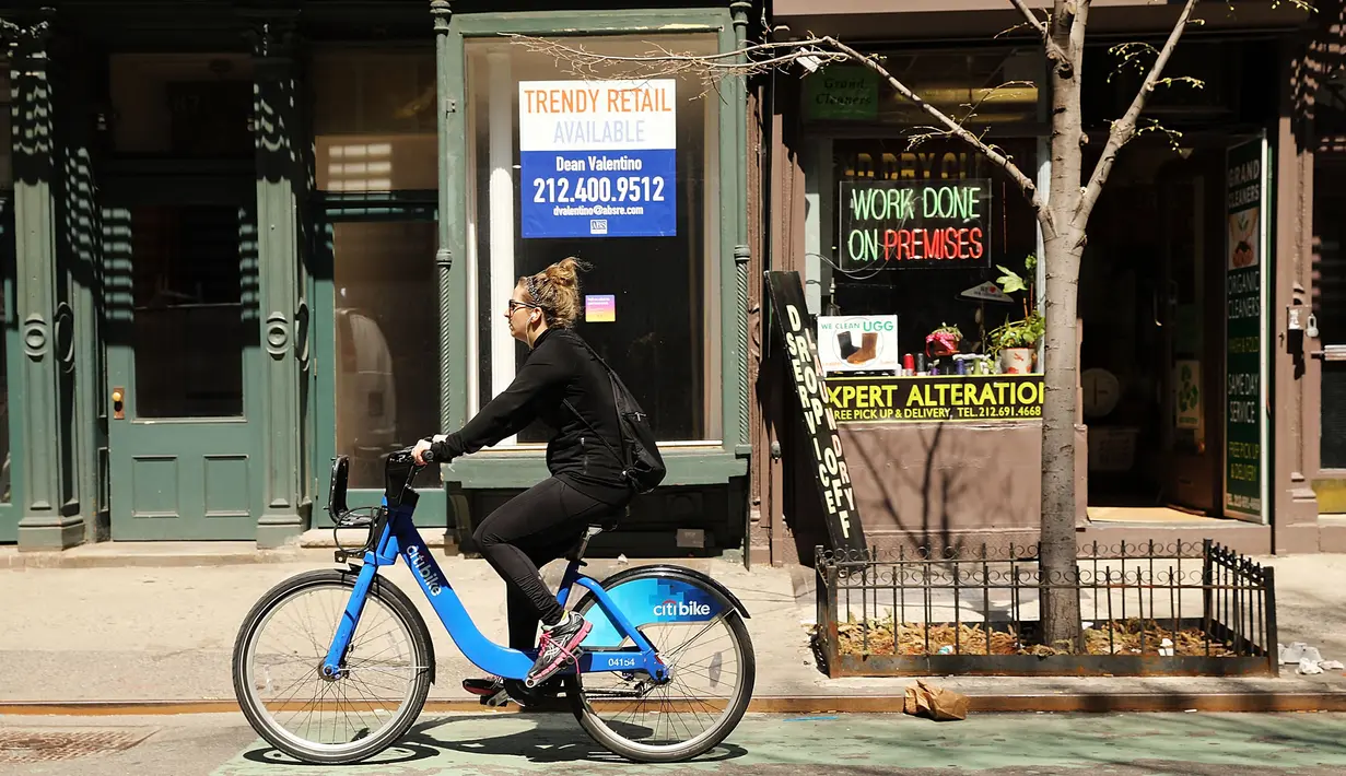 Warga melintas di depan toko yang tutup di West Village, New York (12/4). Bisnis online shop yang terus berkembang membuat sejumlah toko gulung tikar karena sewa yang naik. (Spencer Platt / Getty Images / AFP)