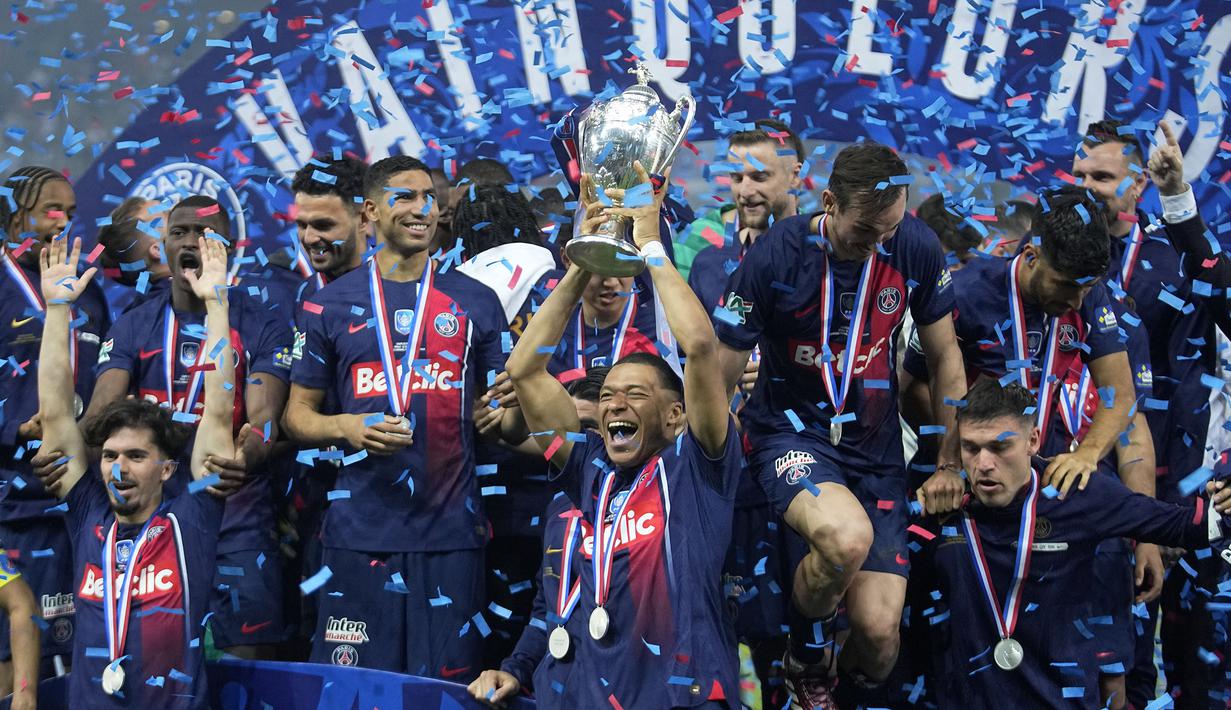 Pemain PSG, Kylian Mbappe (tengah) mengangkat trofi Coupe De France 2023/2024 saat perayaan gelar juara di Stade Pierre-Mauroy, Villeneuve-d'Ascq, Prancis, Minggu (26/05/2024) WIB. PSG menang dengan skor 2-1 atas Olympique Lyon pada babak final. (AP Photo/Michel Euler)