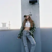 Lisa tampil kece dengan crop tee, kemeja flanel, jeans, black boots. Tak lupa topi dan hoop earrings sebagai aksesori pelengkap (Instagram/lalalalisa_m).