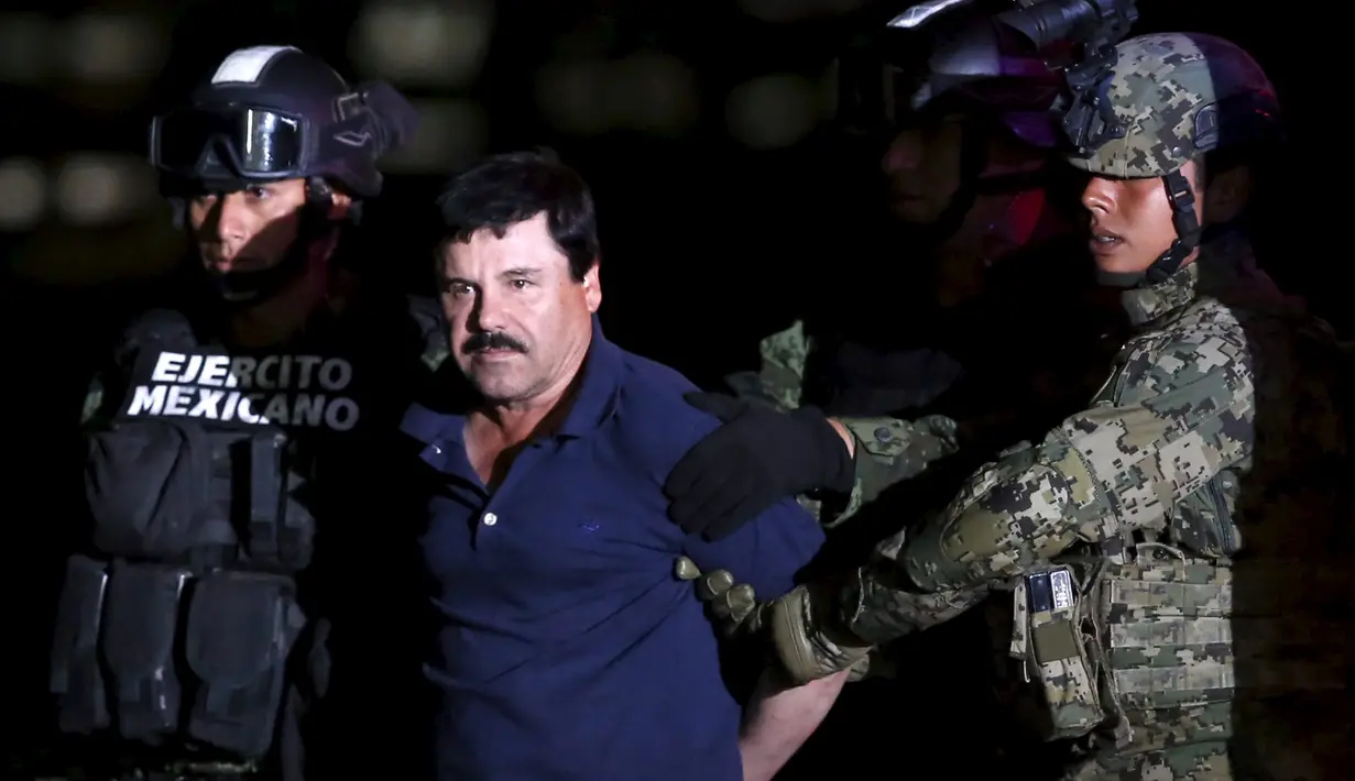 Ekspresi bos narkoba Joaquin "El Chapo" Guzman saat dikawal ketat oleh tentara di kantor Kejaksaan Agung, Meksiko (8/1/2016). Joaquin "El Chapo" Guzman melarikan diri dari penjara melalui terowongan yang ia buat pada 11 Juli 2015. (REUTERS/Henry Romero)