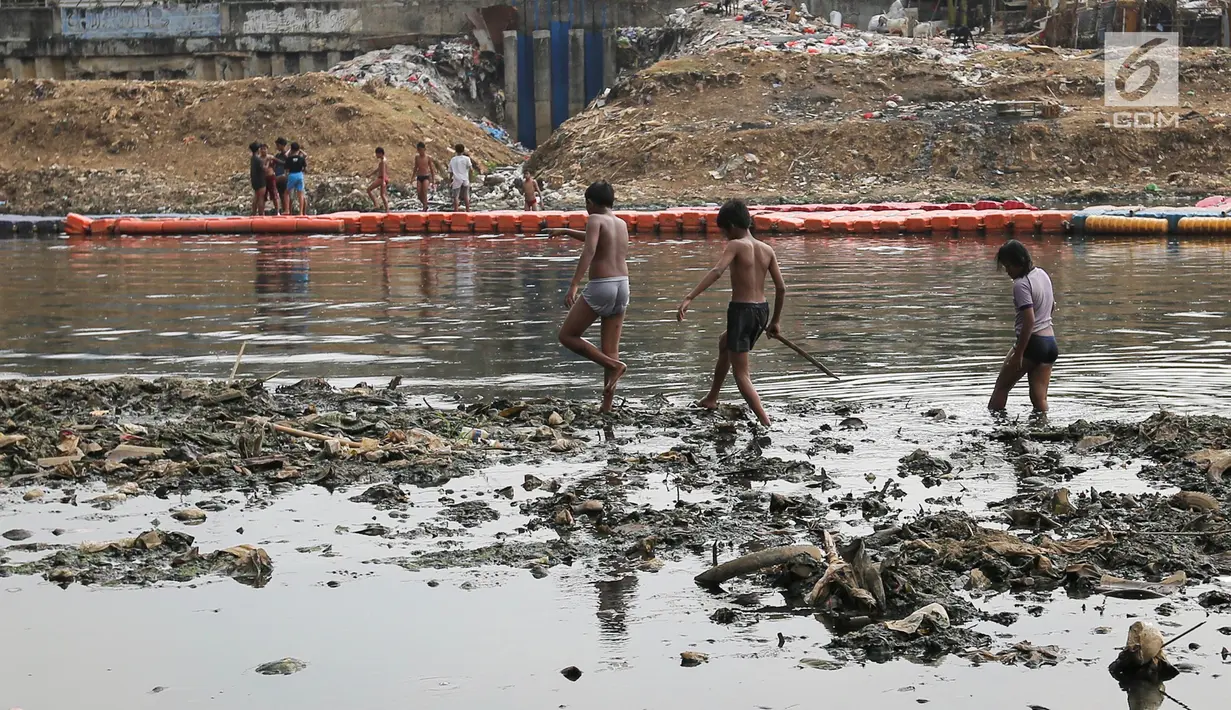 Anak-anak usai berenang di Kanal Banjir Barat (KBB) yang hitam di Petamburan, Jakarta, Senin (12/8/2019). Anak-anak memanfaatkan waktu pulang sekolah mereka untuk berenang dan mencari ikan di KBB saat musim kemarau. (Liputan6.com/Fery Pradolo)
