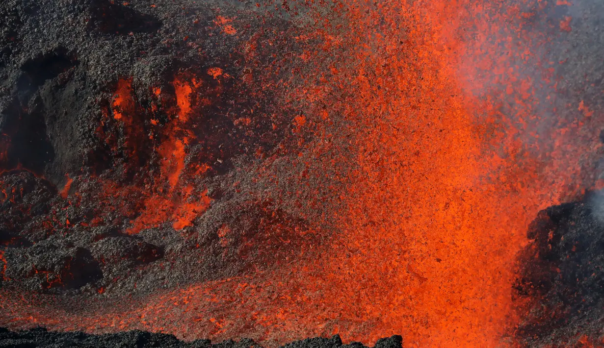 Semburan lava pijar dari Gunung Piton de la Fournaise, La Reunion, Prancis, Rabi (1/2). Gunung tersebut kembali meletus pada Selasa (31/1) malam waktu setempat dan terus menyemburkan lava pijar. (AFP Photo/Richard Bouhet)