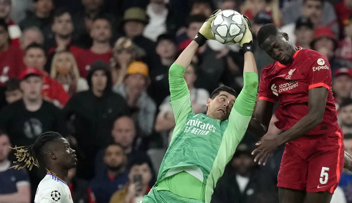 Kiper Real Madrid, Thibaut Courtois (kiri) menangkap bola di depan pemain Liverpool, Ibrahima Konate laga final Liga Champions antara Liverpool melawan Real Madrid yang berlangsung di Stade de France, Saint Denis, Sabtu, 28 Mei 2022 waktu setempat. (AP/ Kirsty Wigglesworth)