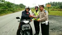 Sebagai imbalan bagi warga yang lengkap selama berkendara, jajaran Polda Riau di Siak dan Pekanbaru, memberikan hadiah berupa mawar dan jam dinding. (Liputan6.com/M Syukur)