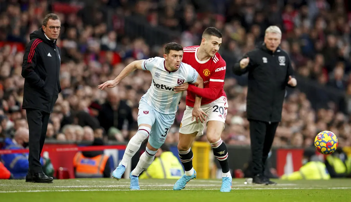 Pemain Manchester United Diogo Dalot (tengah kanan) berebut bola dengan pemain West Ham United Aaron Cresswell pada pertandingan sepak bola Liga Inggris di Stadion Old Trafford, Manchester, Inggris, 22 Januari 2022. Manchester United menang 1-0. (AP Photo/Dave Thompson)