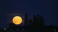 Bulan purnama yang dikenal sebagai Harvest moon muncul di atas Whitby Abbey, di Whitby, Inggris, Senin (20/9/2021). Bulan purnama Harvest Moon biasanya terjadi di bulan September, namun kadang juga terlambat hingga ke Oktober. (AP Photo/Alastair Grant)