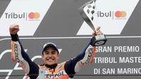 Pembalap Repsol Honda, Marc Marquez memegang trofi juara balapan MotoGP San Marino 2017 di atas podium Sirkuit Misano, Italia, Minggu (10/9). Marquez sukses mencatat waktu 50 menit 41,565 detik, terpaut 1,192 detik. (AP Photo/Antonio Calanni)