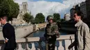 Seorang tentara melakukan patroli setelah aksi penyerangan oleh pria bersenjata palu di luar Katedral Notre-Dame, Paris, Selasa (6/6). Kawasan di sekitar katedral telah ditutup dan orang-orang diminta untuk tidak mendekat. (AP Photo/Christophe Ena)