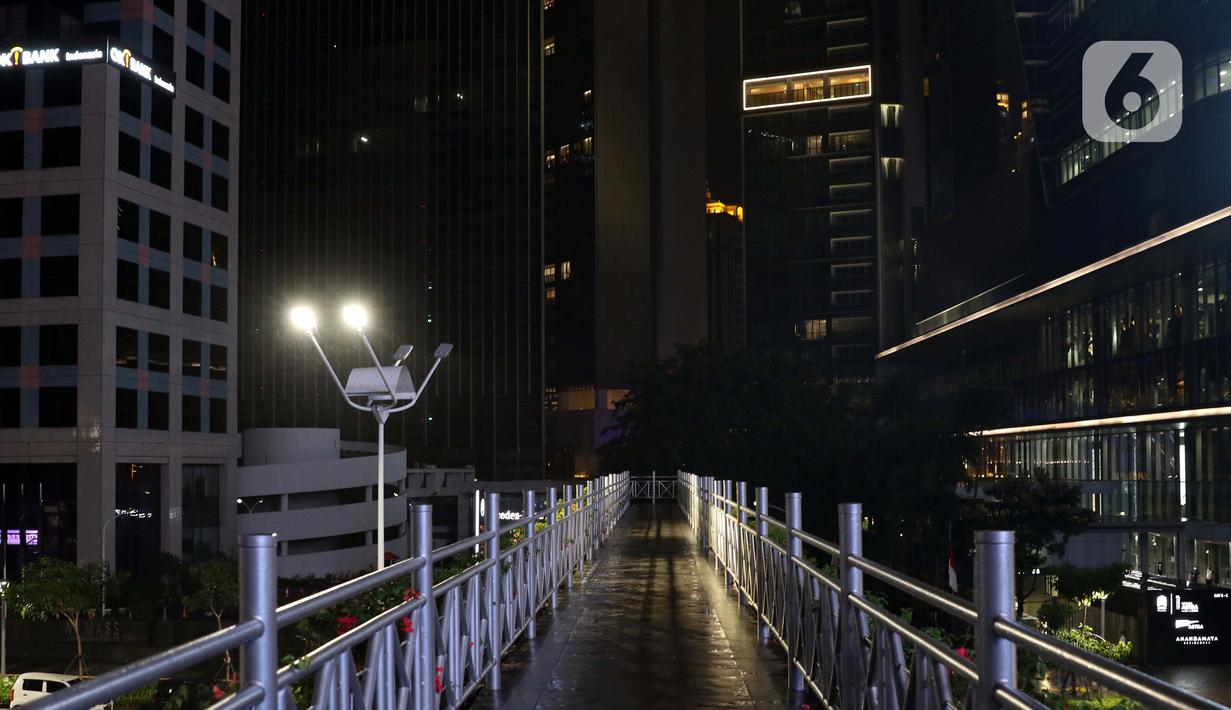Suasana JPO tanpa atap di jalan Jenderal Sudirman pada malam hari, Jakarta, Selasa (15/9/2020). Guna mengurangi pola penyebaran COVID-19, Pemda DKI Jakarta kembali menerapkan PSBB dengan membatasi aktivitas warga, perdagangan maupun perkantoran. (Liputan6.com/Helmi Fithriansyah)