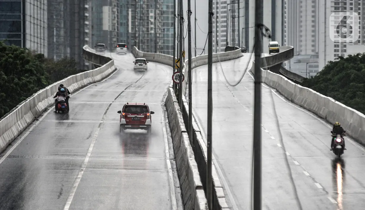Pengendara sepeda motor (kiri) mengalami mogok saat menerobos Jalan Layang Non Tol (JLNT) Casablanca saat hujan, Jakarta, Minggu (20/12/2020). Aksi nekat para pengendara sepeda motor tersebut dapat mengancam keselamatan diri serta pengguna jalan lain. (merdeka.com/Iqbal S. Nugroho)