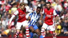 Pemain Arsenal Martin Odegaard (kiri), berduel memperebutkan bola dengan pemain Brighton Danny Welbeck dalam pertandingan lanjutan Liga Inggris di Stadion Emirates, Sabtu (9/4/2022) malam WIB. (AP Photo/Ian Walton)