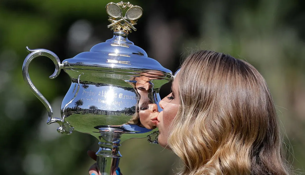 Caroline Wozniacki mencium piala Australia Terbuka 2018 di Royal Botanical Gardens di Melbourne, Australia, (28/1). Petenis Denmark ini berhasil mengalahkan petenis Rumania Simona Halep 7-6, 3-6, 6-4 di babak Final. (AP Photo / Dita Alangkara)
