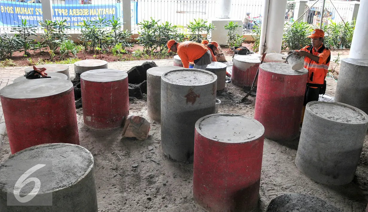 Petugas PPSU melakukan penambalan di tempat duduk beton di taman Interaktif FO Klender, Jakarta, Rabu (10/2). Pihak Kecamatan Pulogadung dan Kelurahan Jatinegara mulai perbaiki fasilitas taman sebelumnya rusak parah. (Liputan6.com/Yoppy Renato)