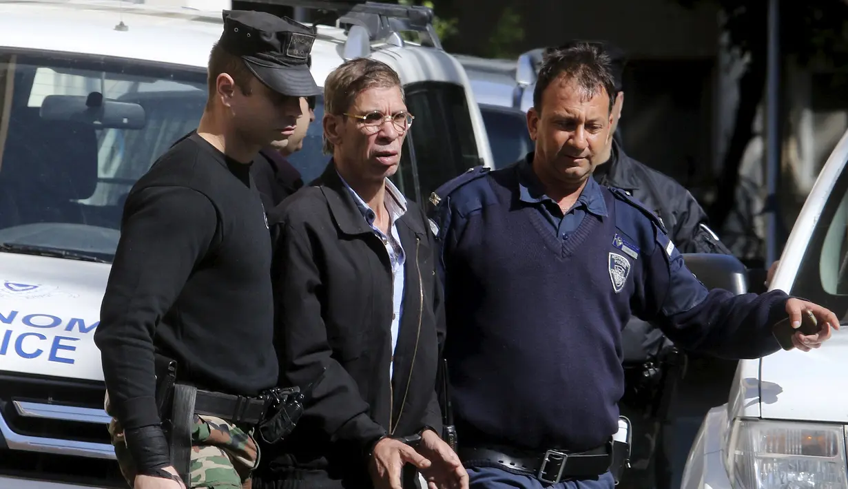 Seif Eldin Mustafa saat digelandang petugas kepolisian untuk dibawa ke pengadilan di Larnaca, Siprus, Rabu (30/3). Aksi nekat Mustafa hingga membajak EgyptAir masih diselidiki petugas. (REUTERS/Yiannis Kourtoglou)