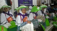 Para Calhaj KBIH AL Munawaroh Cilacap membawa tudung untuk melindungi diri dari terik matahari saat berada di tanah suci. (Foto: Liputan.com/Muhamad Ridlo).