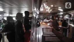 Pemudik saat memesan makanan ringan di kantin kapal saat perjalanan mudik menuju Pelabuhan Bakauheni, Lampung Selatan, Sabtu (30/4/2022). Namun, fasilitas kapal laut kelas reguler masih sangat terbatas, tidak ada kamar khusus penumpang sehingga banyak pemudil memilih duduk atau tidur di deck dan lorong kapal. (merdeka.com/Iqbal S. Nugroho)