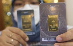 Petugas memperihatkan emas batangan yang dijual di Galeri 24 Pegadaian, Jakarta, Jumat (25/3/2022). Harga emas Antam di Pegadaian kembali naik. Hari ini harga emas Antam naik Rp 6.000 menjadi Rp 1 juta per gram, pada 25 Maret 2022. (Liputan6.com/Angga Yuniar)