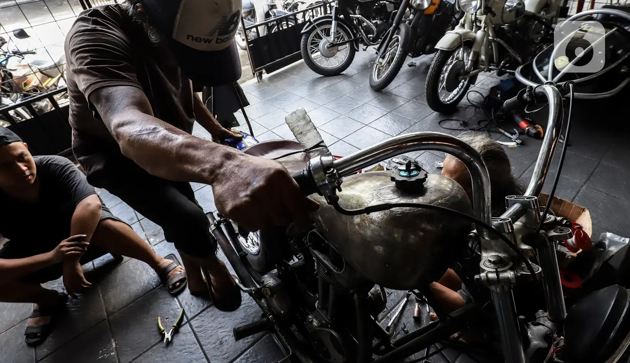 Pegawai bengkel motor custom menyelesaikan perakitan sepeda motor modifikasi di Classic Batavia Garage, Jakarta Selatan, Selasa (22/6/2021). Pandemi covid-19, bengkel Classic Batavia Garage kebanjiran jasa service dan modifikasi motor-motor sesuai dengan pesanan pelanggan. (Liputan6.com/Johan Tallo)