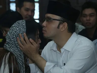 Tersangka Sandy Tumiwa mencium istrinya saat akan menjalani sidang di Pengadilan Jakarta Pusat, Selasa (1/3/2016). Sidang penipuan dengan tersangka Sandy Tumiwa kembali digelar dengan agenda mendengarkan saksi Annisa Bahar. (Liputan6.com/Herman Zakharia)