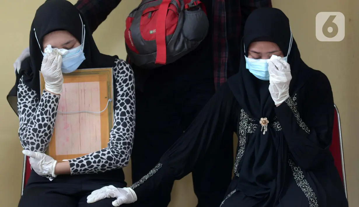 Tangis keluarga korban kecelakaan Sriwijaya Air SJ 182 saat serah terima jenazah di RS Polri, Jakarta, Kamis (14/1/2021). Jenazah korban kecelakaan Sriwijaya Air SJ 182 pertama yang berhasil teridentifikasi, Okky Bisma, akan disemayamkan di TPU Balekambang. (merdeka.com/Imam Buhori)