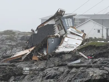 Sisa-sisa rumah yang hancur selama Badai Fiona terlihat di Port aux Basques, Newfoundland dan Labrador, Senin, 26 September 2022. Badai Fiona yang kuat merobek Kanada timur kemarin dengan angin kencang, memaksa evakuasi, merobohkan pohon dan kabel listrik, dan mengurangi banyak rumah di pantai menjadi "hanya tumpukan puing-puing di lautan.". (Frank Gunn/The Canadian Press via AP)