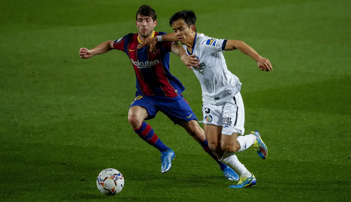 Bek Barcelona, Sergi Roberto berusaha merebut bola gelandang Getafe, Takefusa Kubo pada pertandingan lanjutan La Liga Spanyol di di stadion Camp Nou di Barcelona, Spanyol, Jumat (23/4/2021). Tambahan tiga angka membuat Barcelona kini mengumpulkan 68 angka di urutan ketiga. (AP Photo/Joan Monfort)