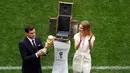 Mantan kiper timnas Spanyol, Iker Casillas didampingi supermodel Rusia,  Natalia Vodianova memamerkan trofi Piala Dunia 2018 sebelum laga pembuka di stadion Luzhniki, Moskow, Kamis (14/6). Trofi Piala Dunia itu terbuat dari emas 18 karat (AP/Darko Bandic)