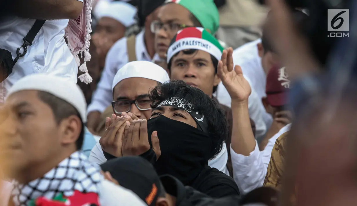 Peserta Aksi Bela Palestina berdoa saat unjuk rasa di kawasan silang Monas, Jakarta, Minggu (17/12). Aksi ini dilakukan untuk menentang keras pengakuan sepihak Presiden AS Donald Trump atas Yerusalem sebagai ibu kota Israel. (Liputan6.com/Faizal Fanani)