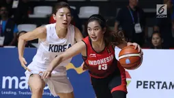 Pebasket putri Indonesia, Christine Aldora Tjundawan (kanan) menghindari kawalan pemain Korea, Lim Yunghui pada babak penyisihan Grup X Basket Putri Asian Games 2018 di Jakarta, Rabu (15/8). Indonesia kalah 40-108. (Liputan6.com/Helmi Fithriansyah)