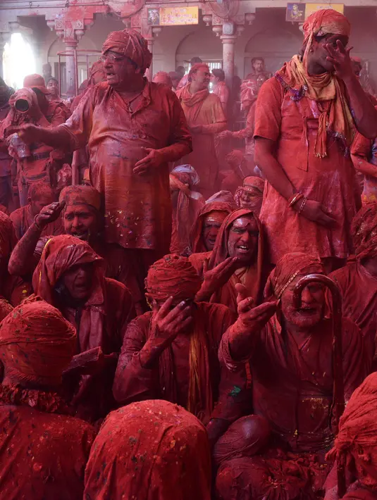 Sejumlah peserta yang tubuhnya berlumuran bubuk merah beristirahat saat mengikuti perayaan Lathmar Holi di Barsana, Uttar Pradesh, India (6/3). (AFP Photo/STR)
