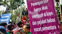 Pengemudi ojek online membentangkan spanduk tuntutan saat melakukan aksi di depan Balai Kota Jakarta, Rabu (8/2/2023). Dalam aksinya, mereka menolak penerapan jalan berbayar atau electronic road pricing (ERP) diterapkan di Jakarta. (Liputan6.com/Angga Yuniar)