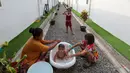 Seorang ibu memandikan anaknya di lingkungan Hunian Sementara (Huntara) di Jalan Kramat Raya, Jakarta, Selasa (8/9/2026). Warga mulai menempati hunian tersebut sejak akhir Juni 2026 setelah sebelumnya tinggal di sekitar bantaran rel kawasan Senen. (KLY/Budy Santoso)