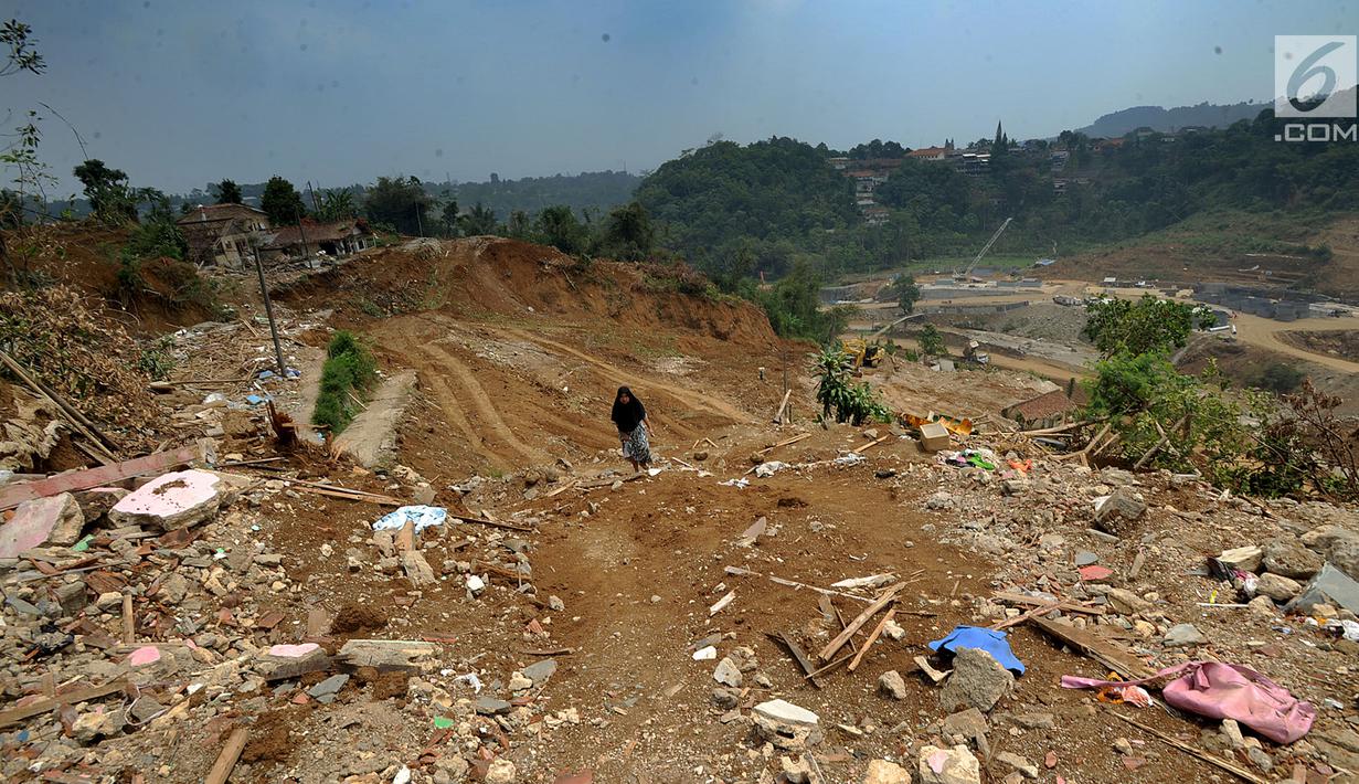 Warga berjalan proyek pembangunan Bendungan Ciawi di Desa Gadog, Bogor, Jawa Barat, Kamis (22/08/2019). Bendungan Ciawi merupakan bendungan kering yang dibangun di kawasan hulu untuk mengendalikan banjir di hilir. (Merdeka.com/Arie Basuki)