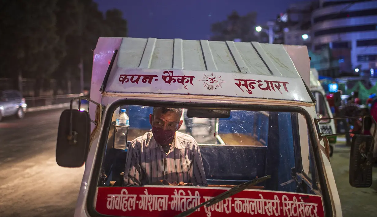 Seorang pengemudi Tuk Tuk Nepal yang mengenakan masker sebagai tindakan pencegahan terhadap virus corona COVID-19 menunggu penumpang di Kathmandu, Nepal, Selasa (13/10/2020). (AP Photo/Niranjan Shrestha)