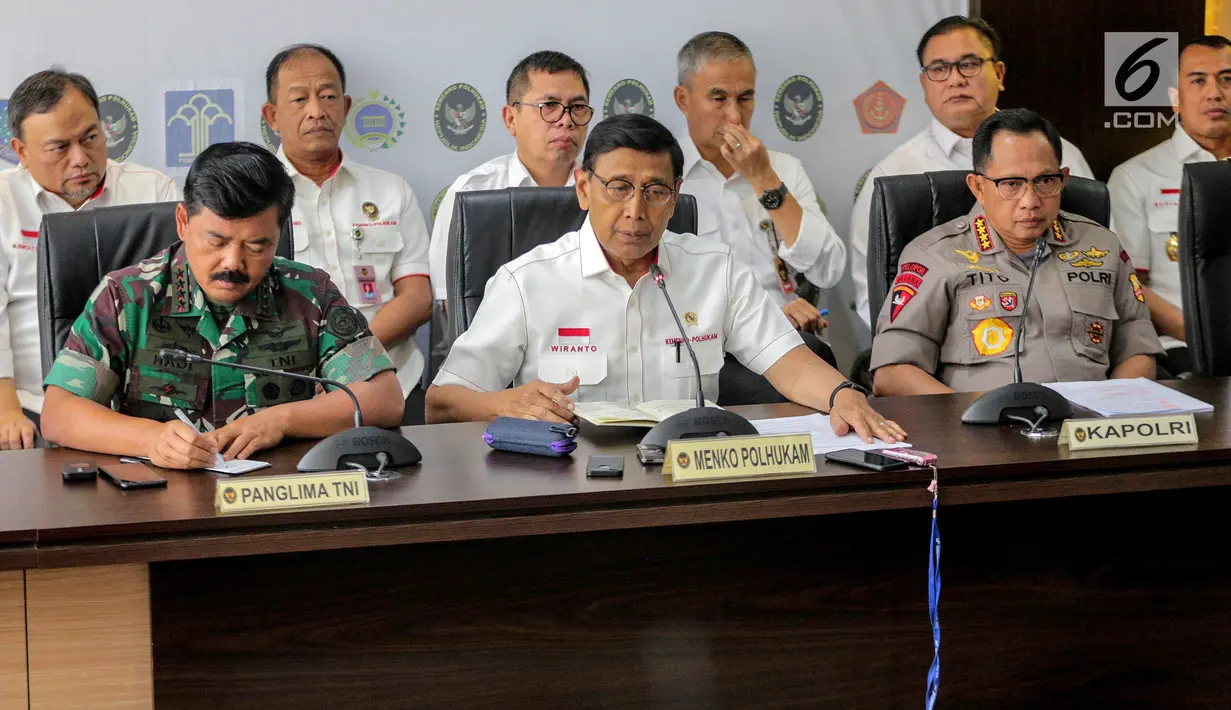 Menko Polhukam Wiranto (tengah) bersama Panglima TNI Marsekal Hadi Tjahjanto (kiri) dan Kapolri Tito Karnavian (kanan) memberi keterangan usai rapat koordinasi tertutup di Kantor Kemenko Polhukam, Jakarta, Selasa (24/9/2019). Rapat membahas isu-isu nasional terkini. (Liputan6.com/Faizal Fanani)