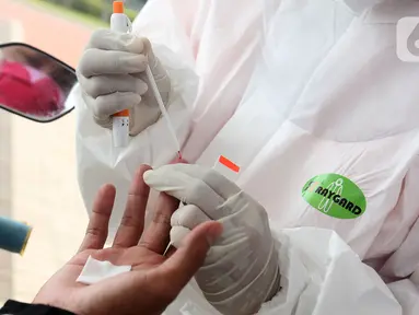Tenaga medis mengambil sampel darah saat rapid test Covid-19 gratis di danau Asya Jakarta Garden City, Jakarta Timur (28/5/2020).Perumahan  Asya memberikan layanan rapid test sebagai upaya membantu pemerintah dalam menekan penyebaran Covid-19 dengan konsep drive thru. (Liputan6.com/Fery Pradolo)