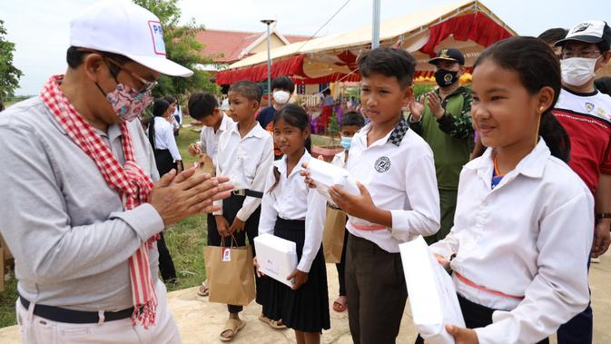 <p>Acara Bakti Kayuh Kemerdekaan menjelang HUT RI ke-77 di Kamboja. Bagi-bagi bingkisan produk Indonesia kepada murid-murid. Dok: KBRI Phnom Penh</p>