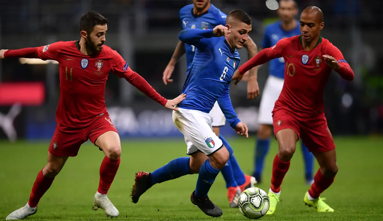 Gelandang Italia, Marco Verratti membawa bola dari kawalan dua pemain Portugal, Bernardo Silva dan Joao Mario selama pertandingan UEFA Nations League di Stadion San Siro, Milan (17/11). Portugal berhasil lolos ke semifinal. (AFP Photo/Marco Bertorello)