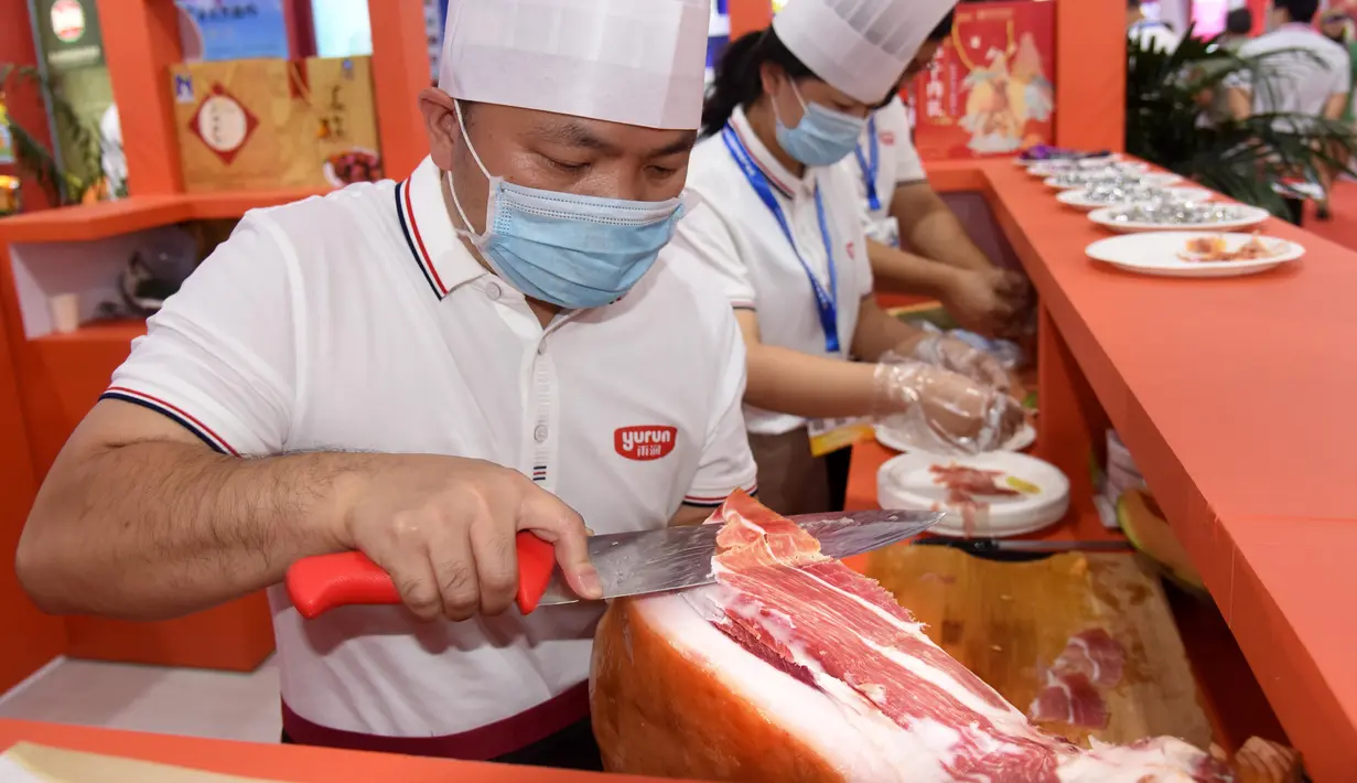 Para peserta pameran menyiapkan produk daging dalam Pameran Industri Daging Internasional China ke-18 di Qingdao, Provinsi Shandong, China, 10 September 2020. (Xinhua/Li Ziheng)