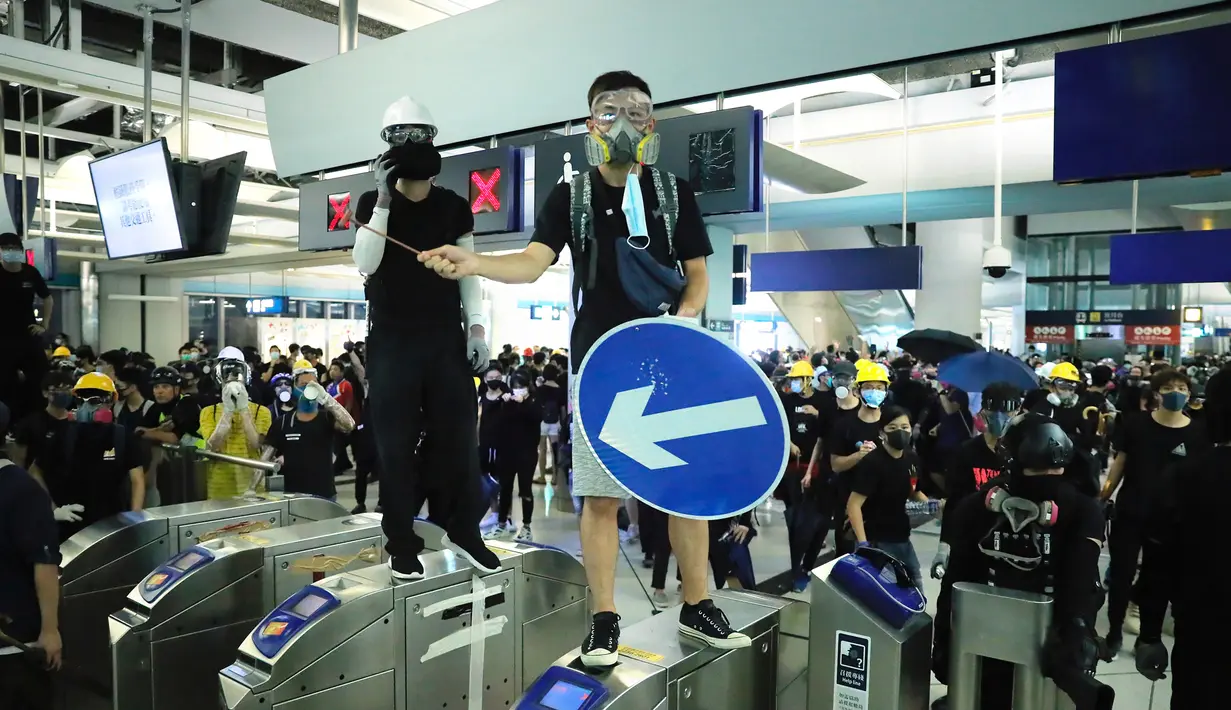 Demonstran berdiri di pintu putar saat berunjuk rasa di Stasiun MTR Yuen Long, Hong Kong, Rabu (21/8/2019). Unjuk rasa ini untuk memperingati serangan pada 21 Juli 2019. (AP Photo/Kin Cheung)