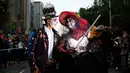 Sepasang peserta berdandan ala tengkorak saat mengikuti parade Hari Orang Mati di Mexico City, Meksiko, Sabtu (26/10/2019. Para peserta dalam parade ini mengenakan kostum dan melukis wajah mirip dengan tokoh tengkorak Meksiko yang ikonik, Catrina. (AP Photo/Ginnette Riquelme)