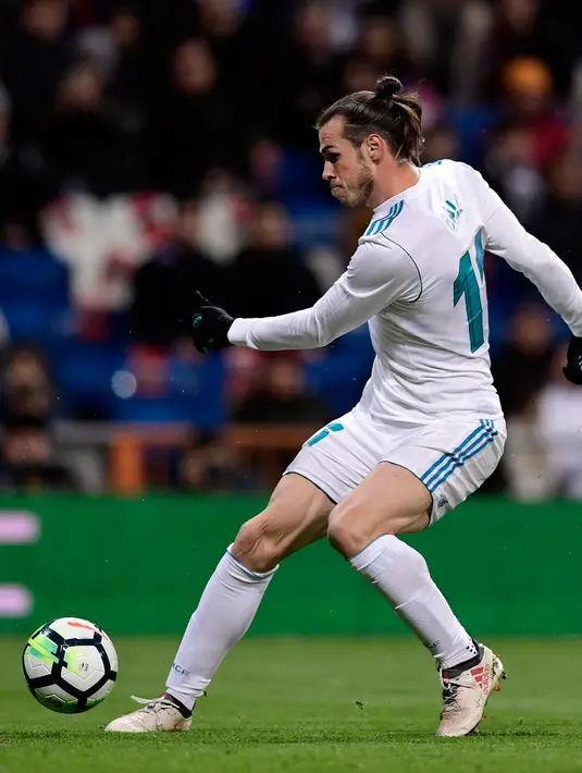 Penyerang Real Madrid Gareth Bale menendang bola yang akhirnya menciptakn gol saat melawan Girona dalam pertandingan La Liga Spanyol di stadion Santiago Bernabeu di Madrid (18/3). (AFP Photo / Javier Sorioano)