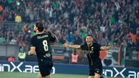 Jay Idzes (kanan) berlari merayakan sukses pemain Venezia, Tanner Tessmann, mencetak gol pada pertandingan Serie B atau kasta kedua Liga Italia. (Bola.com