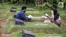 Umat Muslim berdoa di makam keluarga saat  melakukan ziarah di Tempat Pemakaman Umum (TPU) Pondok Ranggon, Jakarta, Minggu (04/04/21). Meskipun di tengah pandemi Covid-19 warga tetap melakukan tradisi ziarah kubur menjelang bulan Ramadan. (Liputan6.com/Faizal Fanani)