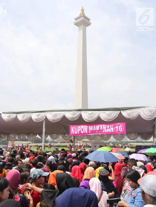 Suasana saat warga antre untuk mendapatkan sembako gratis dalam acara "Untukmu Indonesia" di lapangan Monas, Jakarta, Sabtu (28/4). Selain itu acara juga dimeriahkan dengan doa lintas agama, dan pembagian sembako. (Liputan6.com/Arya Manggala)