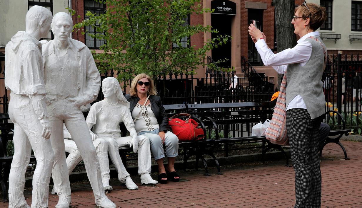  Seorang wanita memotret patung yang disebut 'Gay Liberation' di Christopher Park, Greenwich Village New York City, AS, (9/5). Patung ini dibuat pada tahun 1979 oleh pematung George Segal. (REUTERS / Brendan McDermid)