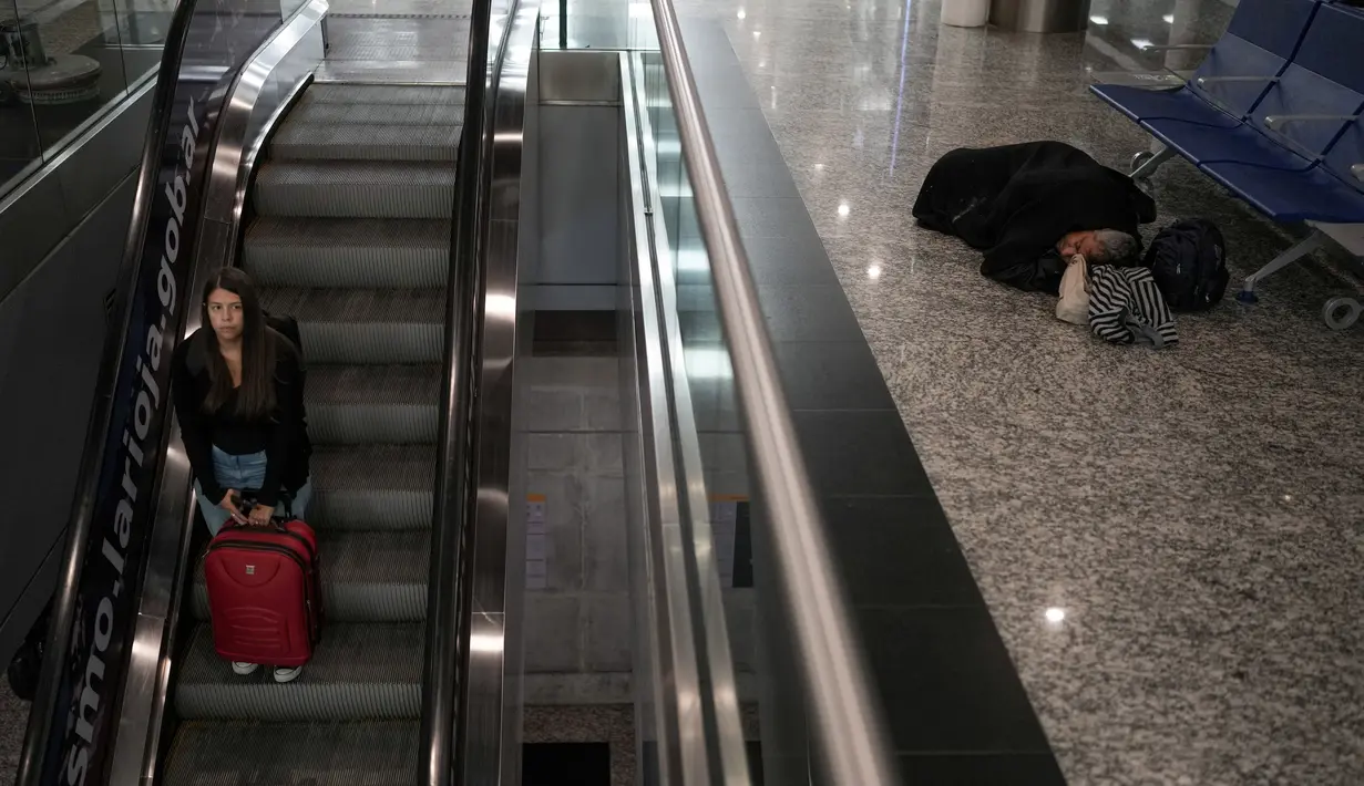 Pada awal akhir pekan Paskah yang panjang, bandara di ibu kota Argentina ini tampak sepi sebelum fajar menyingsing, beberapa jam sebelum bandara ini dipenuhi oleh para pelancong. Sekitar 100 orang yang tidur di dalam fasilitas tersebut bersiap-siap untuk memulai hari mereka. (AP Photo/Natacha Pisarenko)